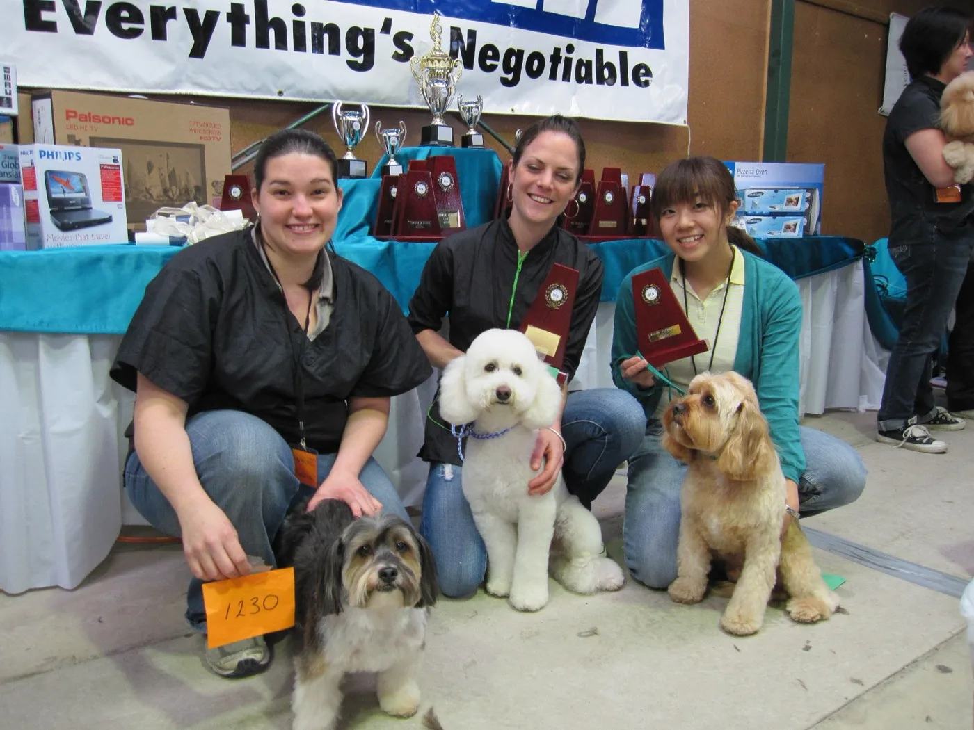 Sayaka and fellow groomers with award plaques and their dogs at a 2010 grooming competition