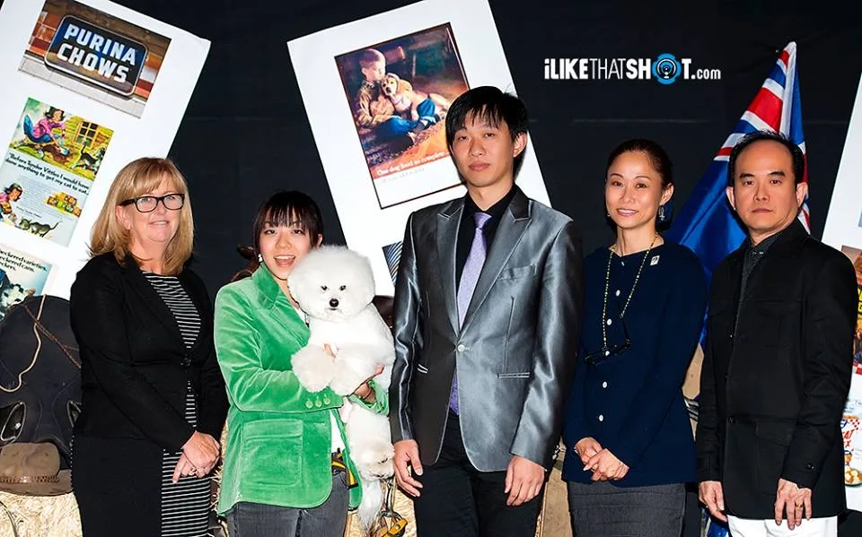 Sayaka holding a white bichon on stage at the Groom Quest awards night, 2013
